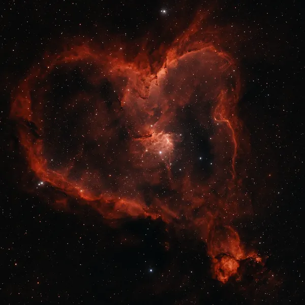 Discover a puzzle with a glowing red heart-shaped nebula set against the deep black of space, scattered with twinkling stars and delicate wisps of cosmic dust.